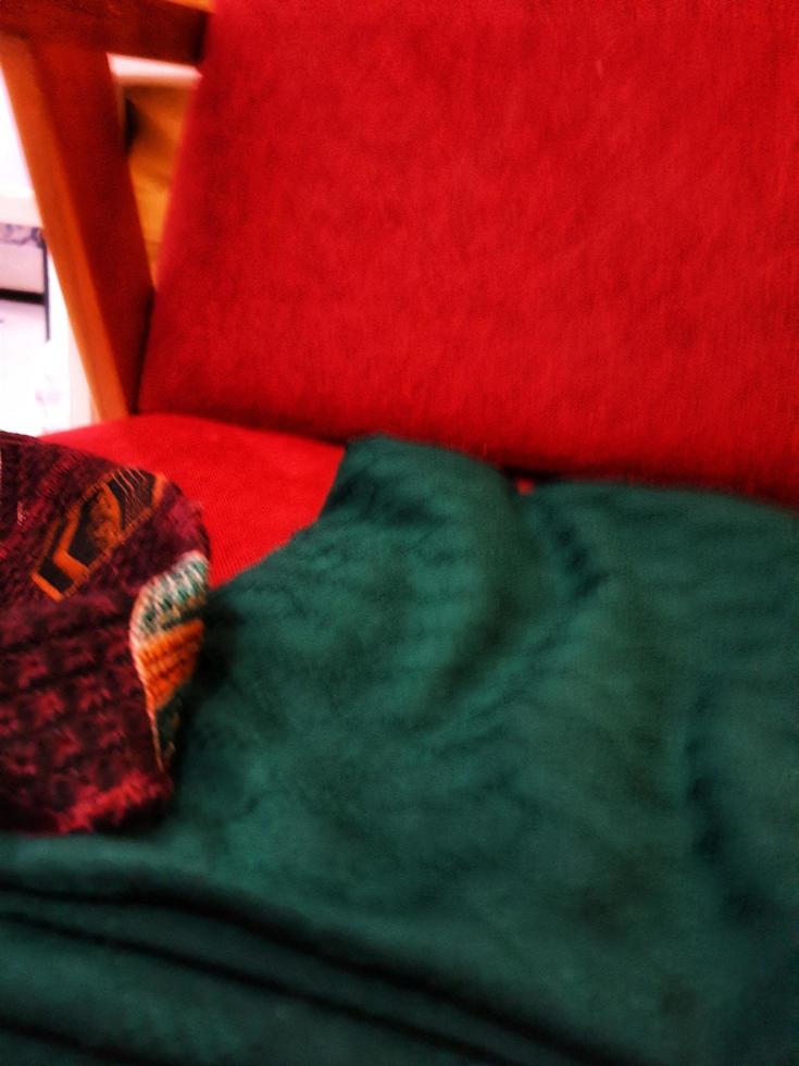 uma verde cobertor em uma vermelho cadeira. foto