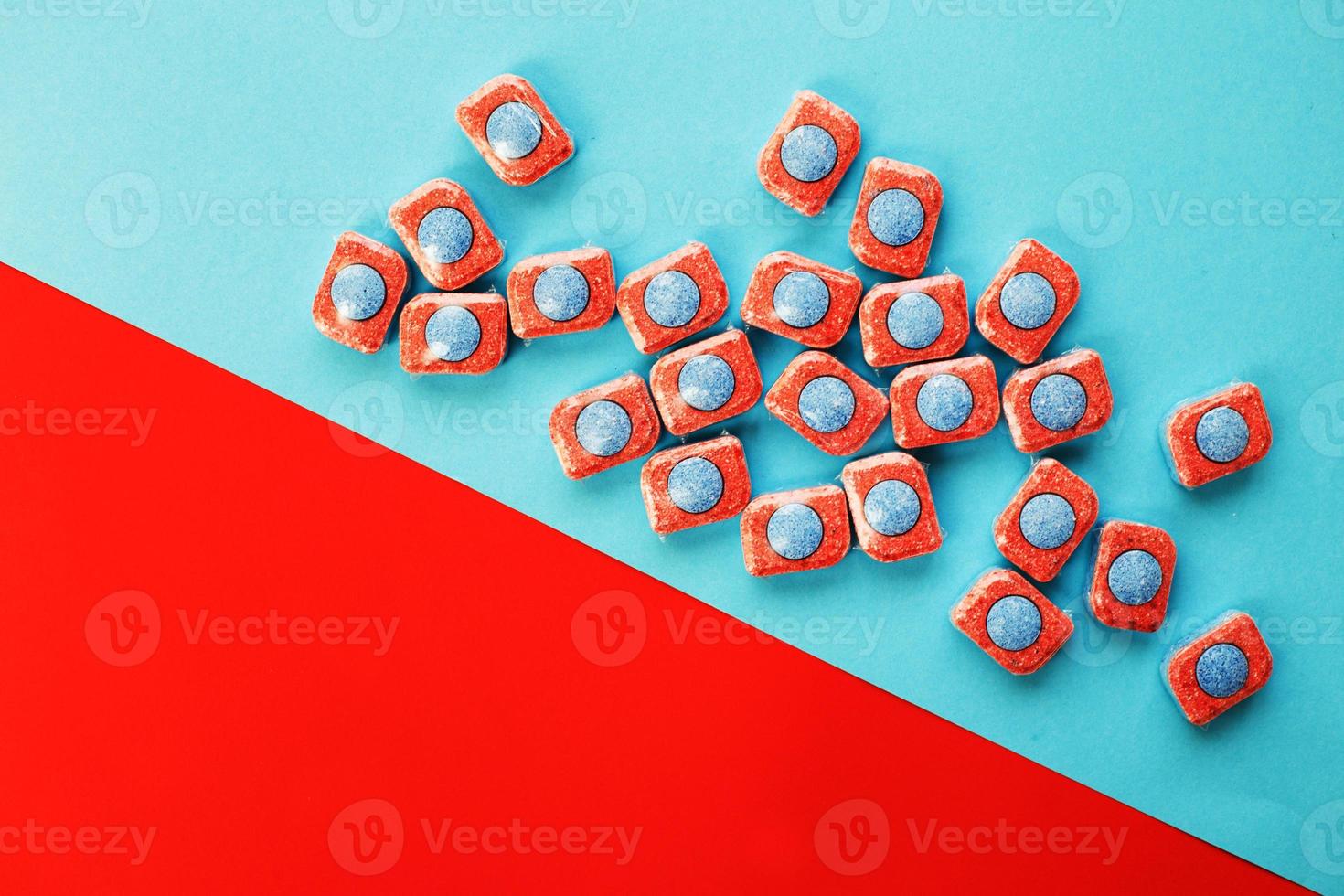 cápsulas para máquinas de lavar louça de cozinha em um fundo azul e vermelho. postura plana. foto