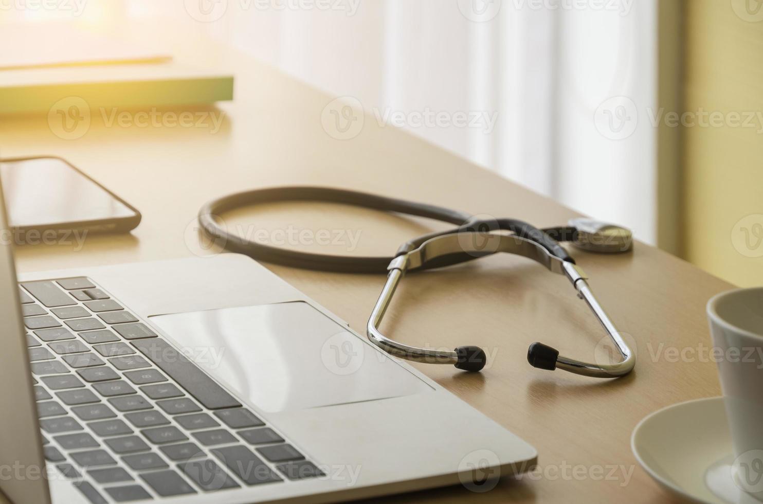 estetoscópio em médico escrivaninha com laboratório, Smartphone, Arquivo pasta e café copo dentro médico sala, foco em estetoscópio. cuidados de saúde conceito. foto