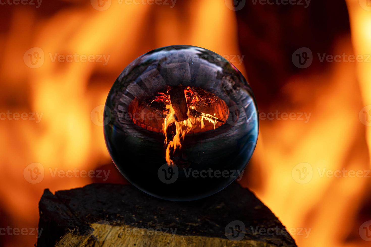 fogueira em uma lareira de pedra refletida em uma bola de vidro foto