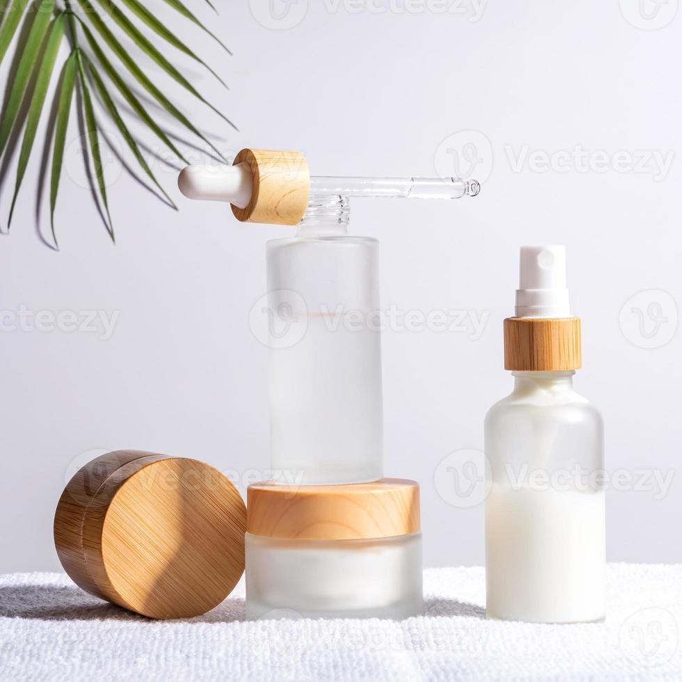 bambu creme jarra e conta-gotas garrafa com face óleo em uma branco fundo. Cosmético recipiente maquetes. fundo para branding e embalagem apresentação. natural cuidados com a pele beleza produtos conceito. foto