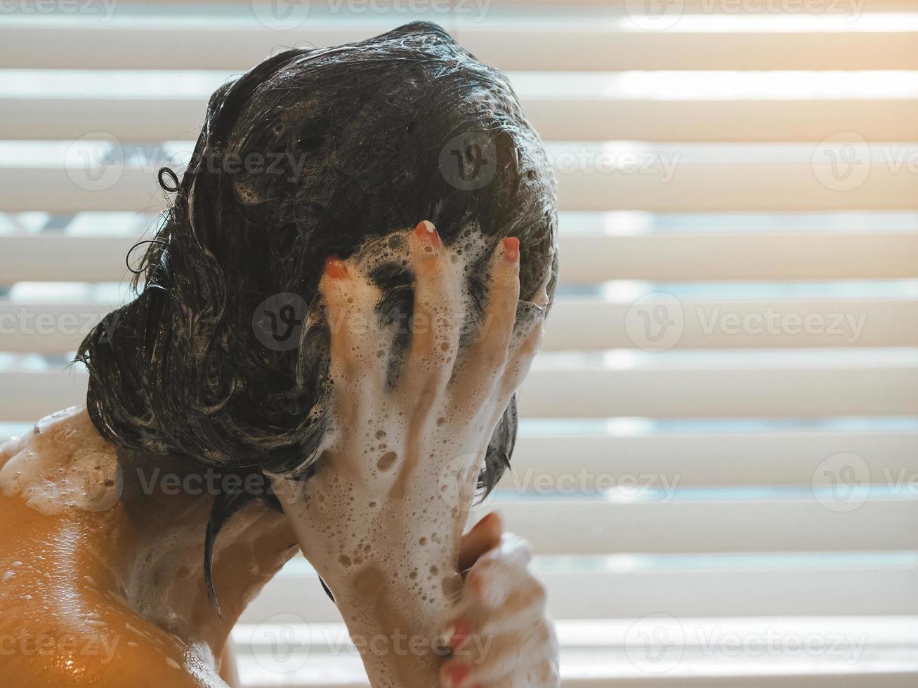 ásia mulher lavando dela cabelo relaxar a partir de trabalhos foto