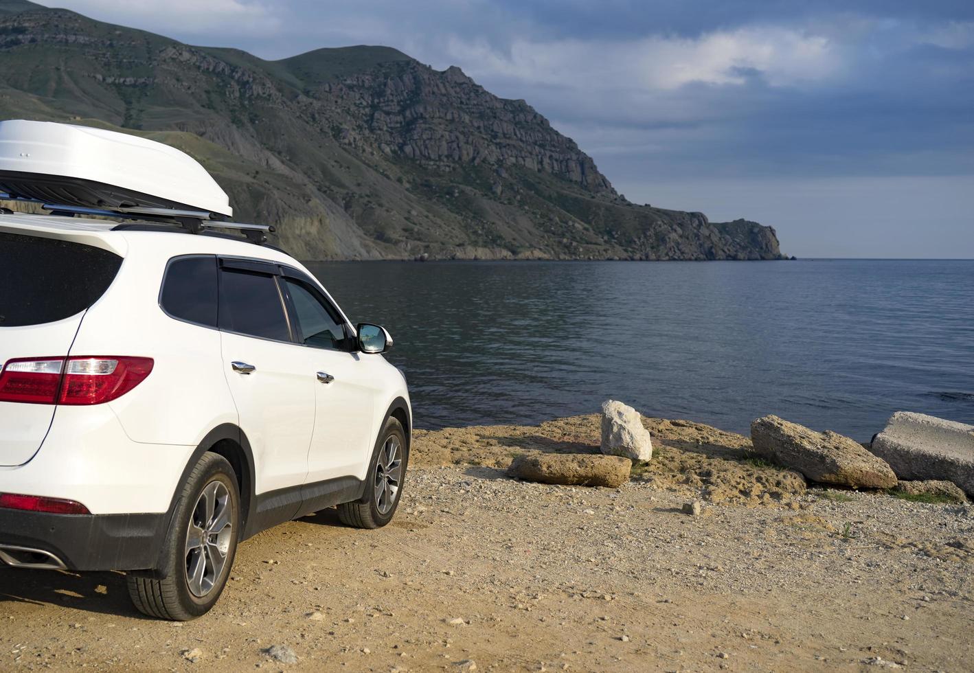 um grande carro branco em frente ao mar. foto