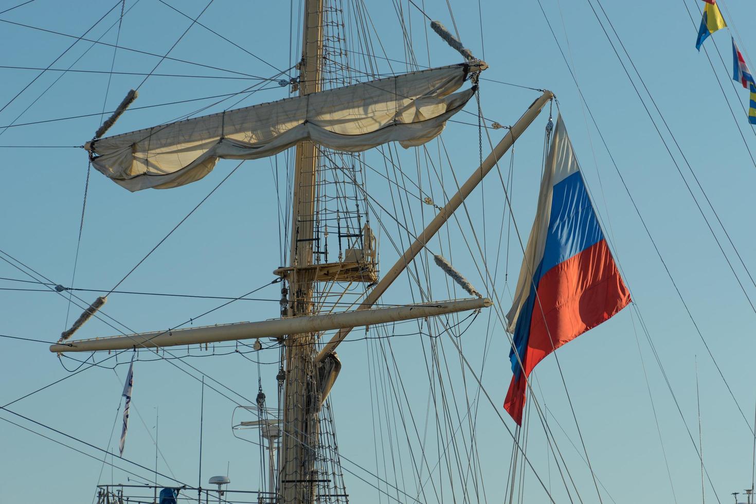 o mastro do veleiro e a bandeira russa contra o céu azul. foto