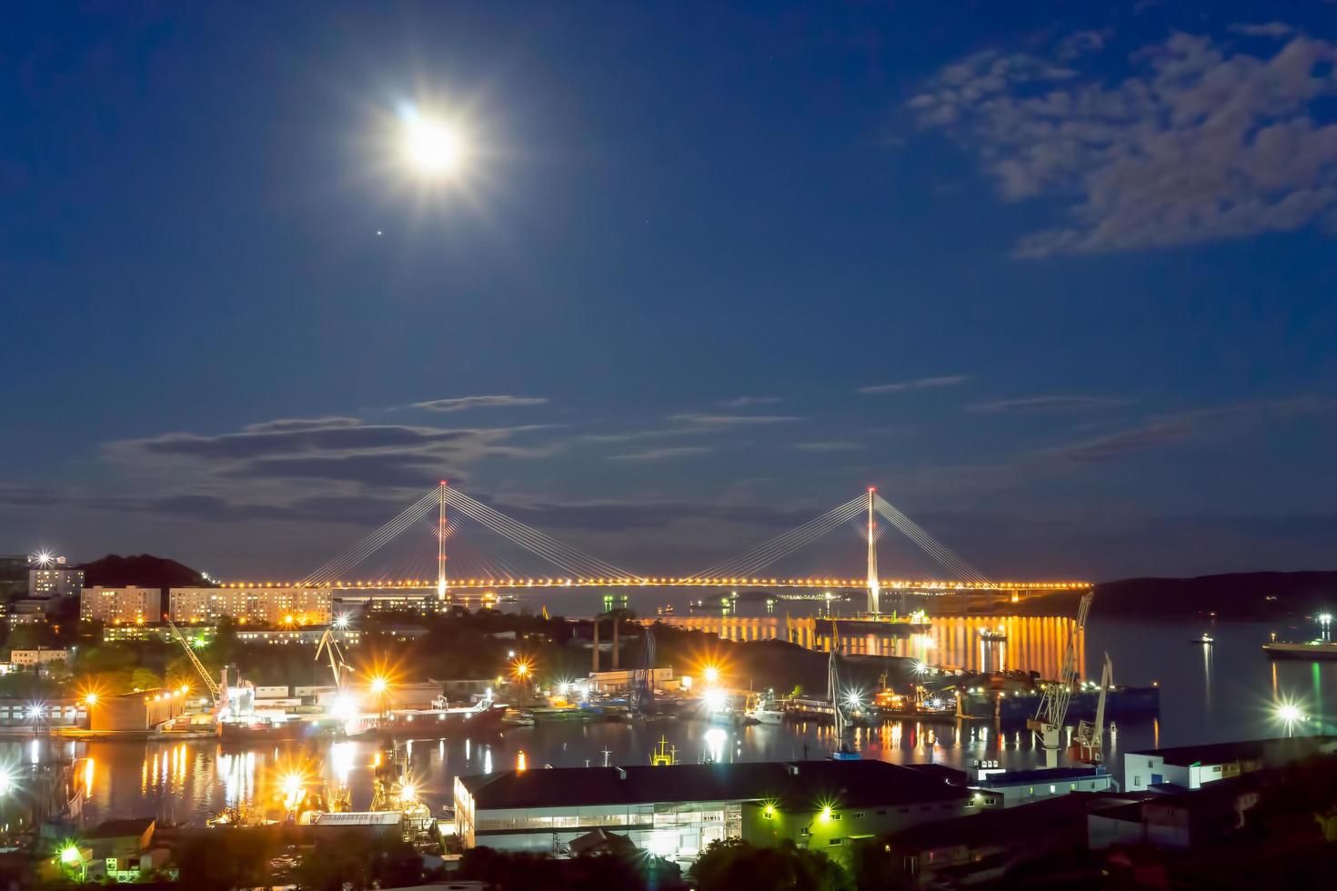 paisagem noturna com vista para a baía de diomida e a ponte russa. foto