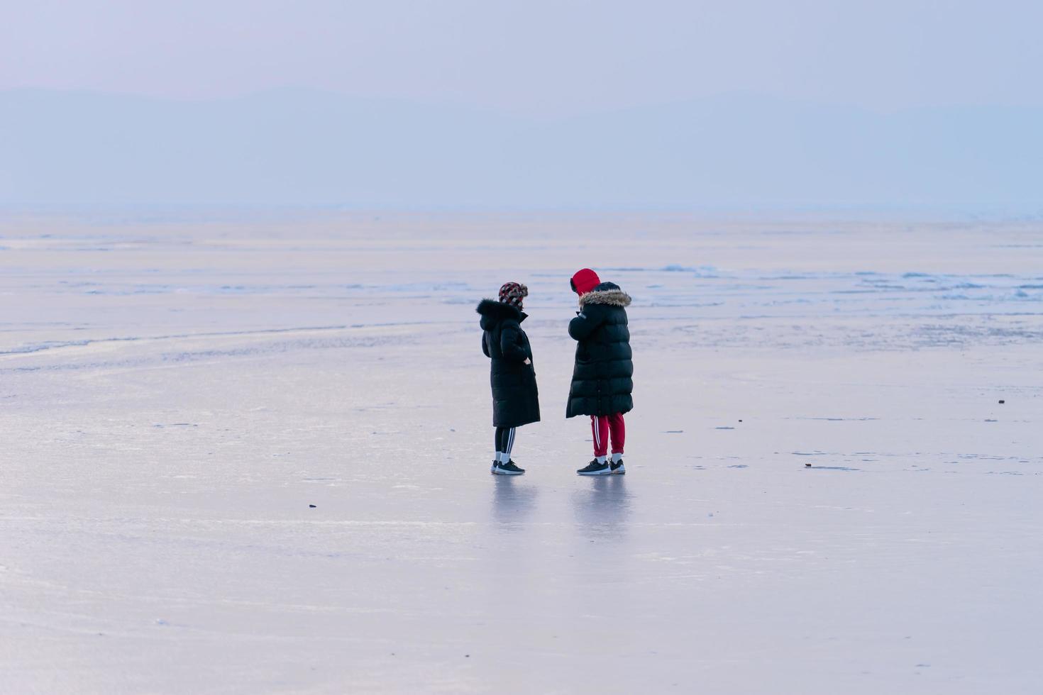 pessoas com roupas de inverno, em pé na superfície gelada do mar. vladivostok. foto