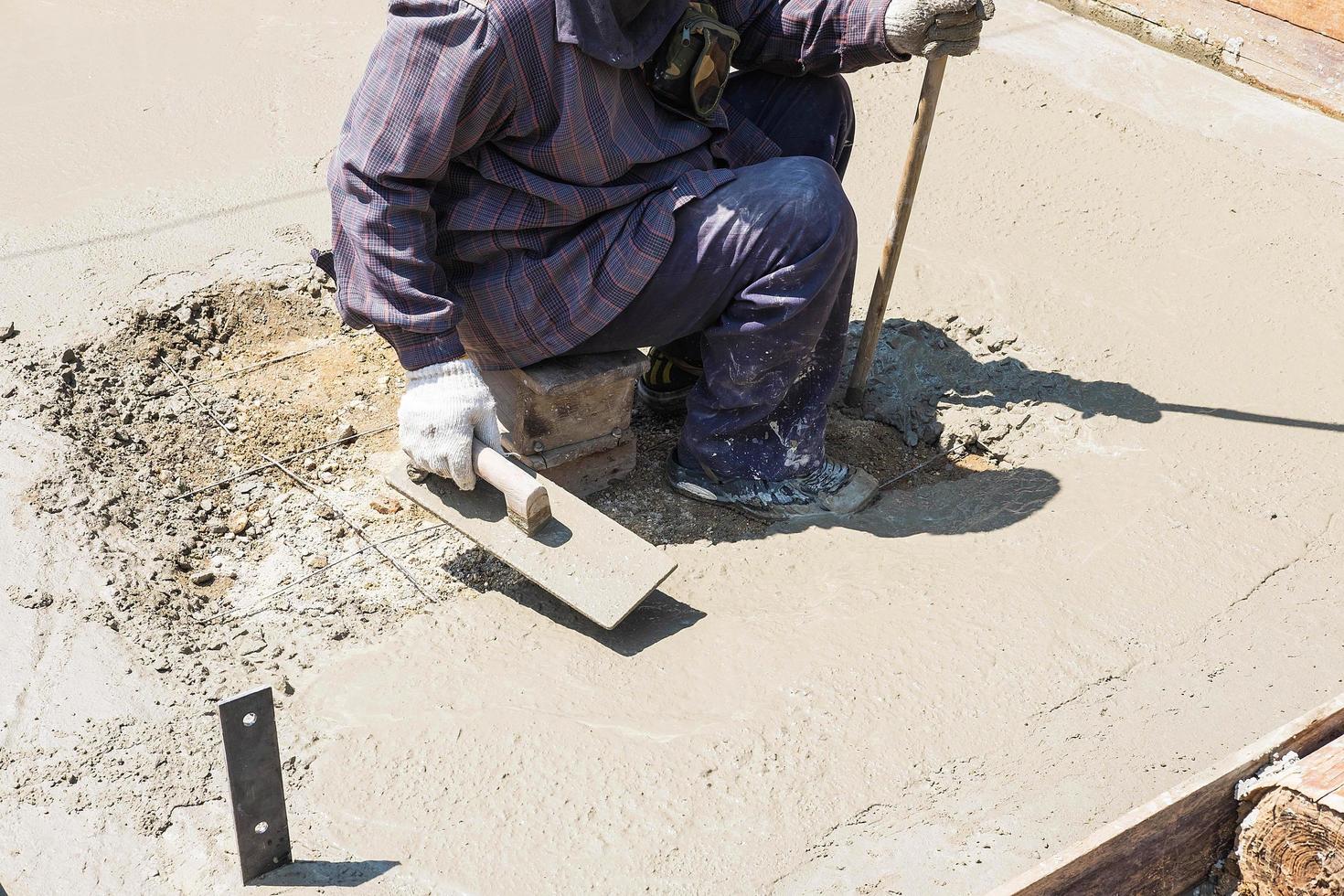 trabalhadores da construção civil rebocando cimento foto