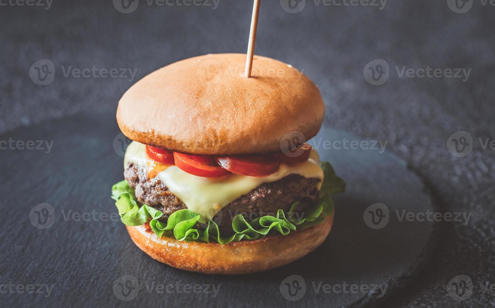 hambúrguer na placa de pedra preta foto