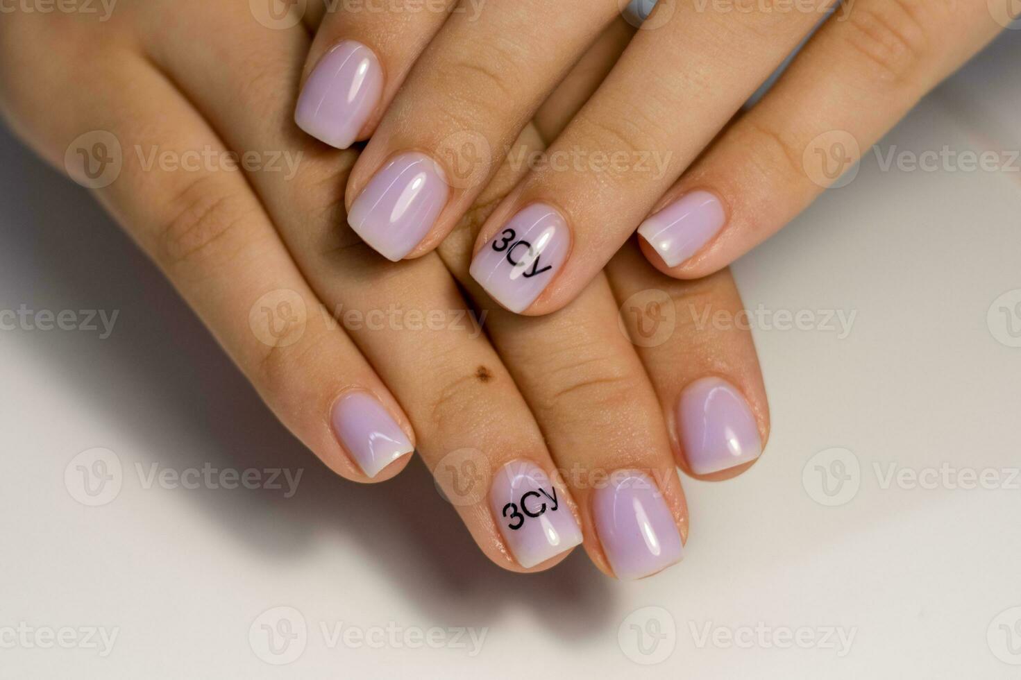 lindo manicure do suave lilás cor em curto quadrado unhas. manicure para mulheres com uma gel polonês Revestimento com uma Preto inscrição foto