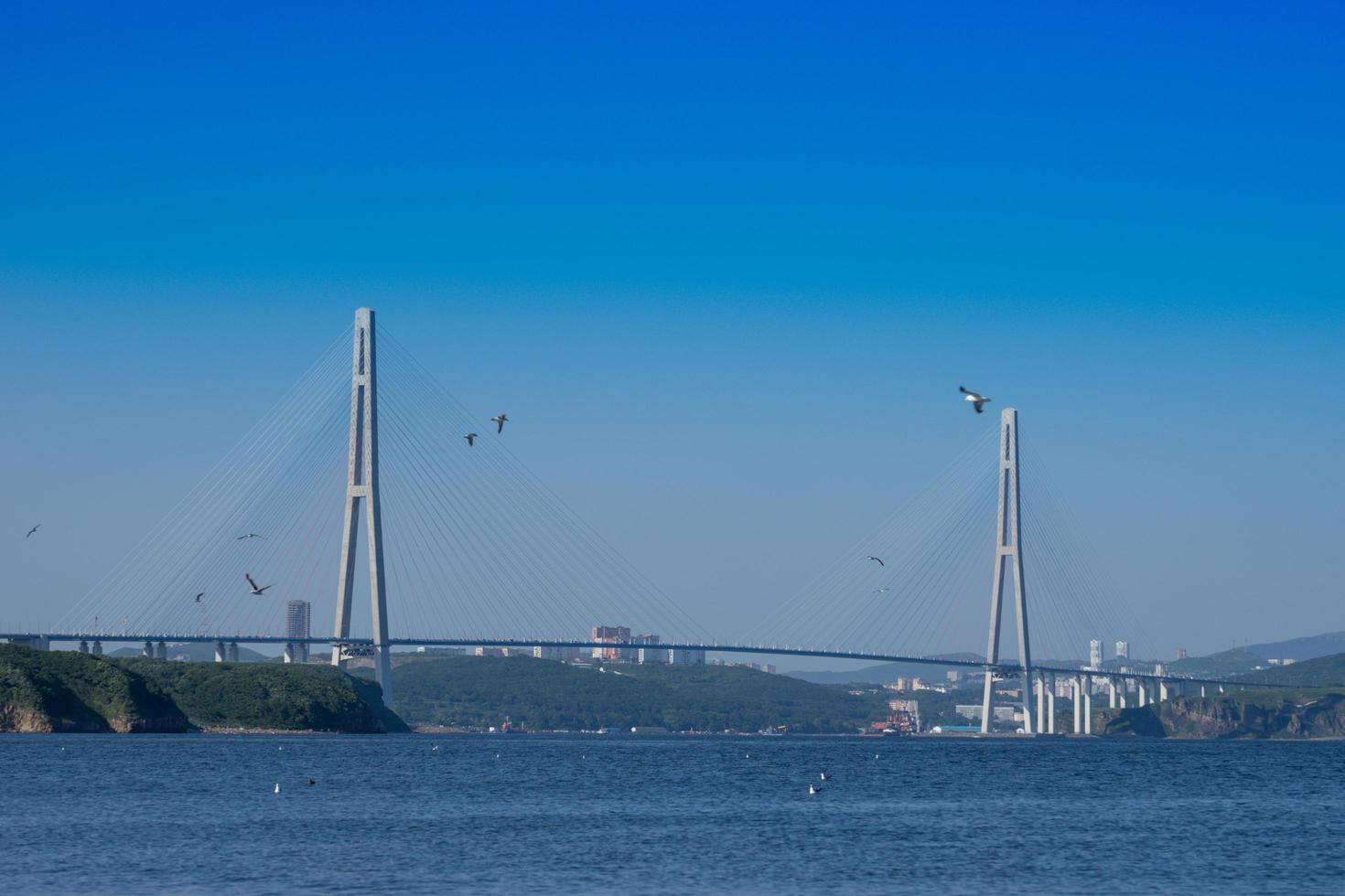 paisagem marinha com vista para a ponte russa no horizonte. foto