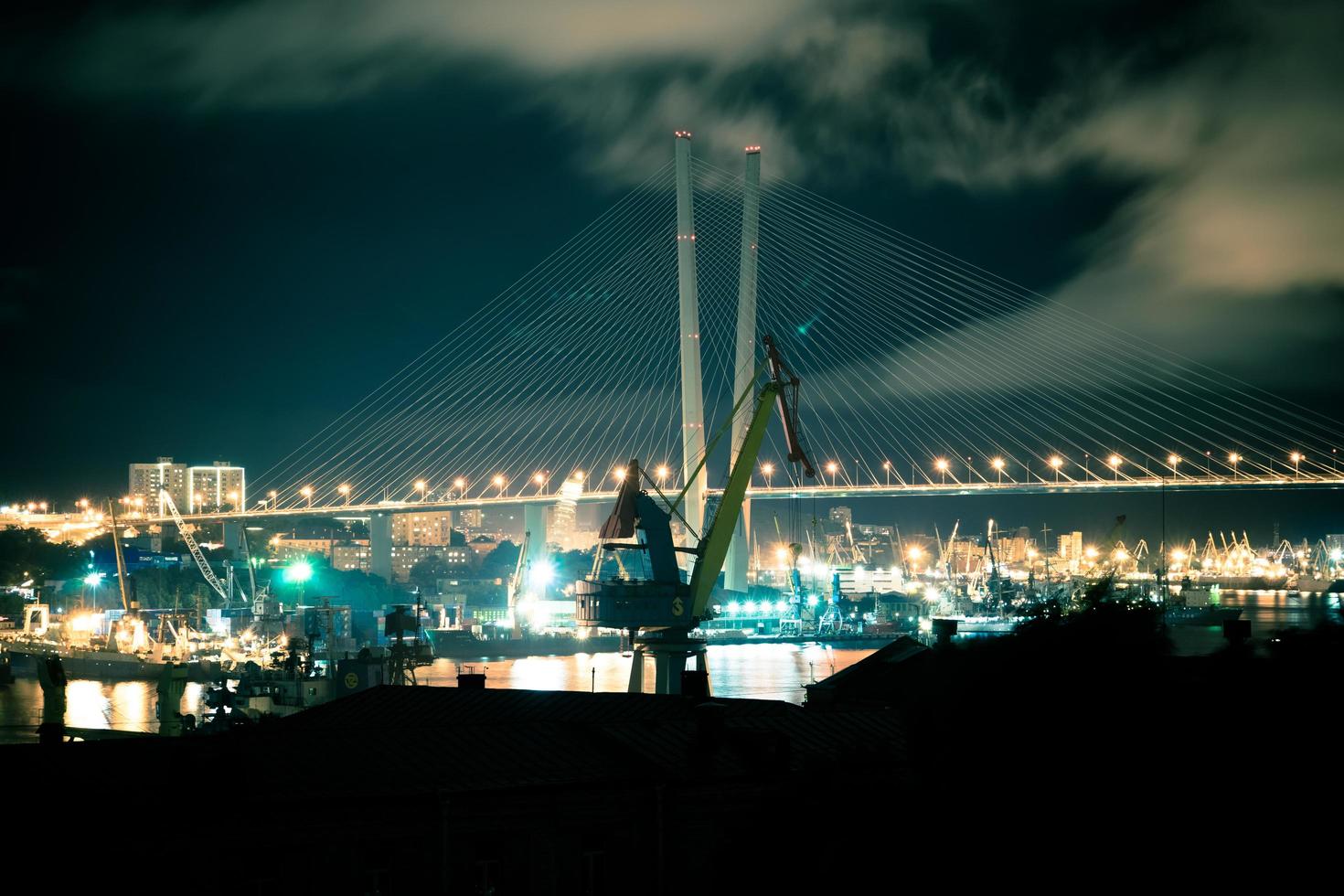 paisagem noturna com guindastes no fundo da ponte dourada. foto