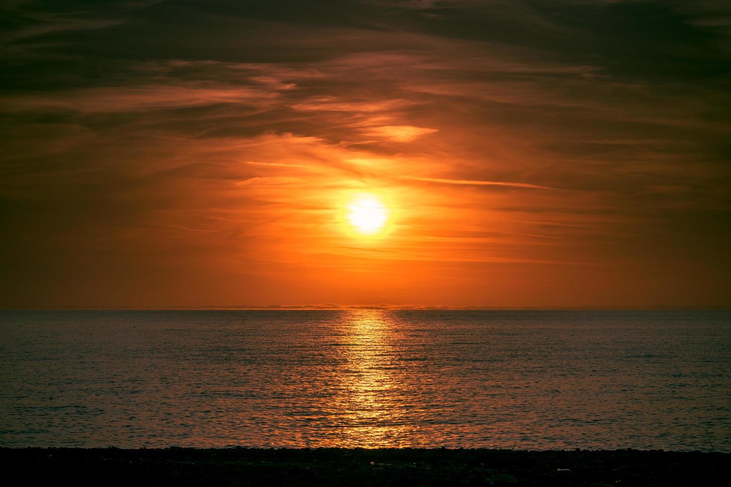 vista do mar com um belo pôr do sol sobre a água. foto