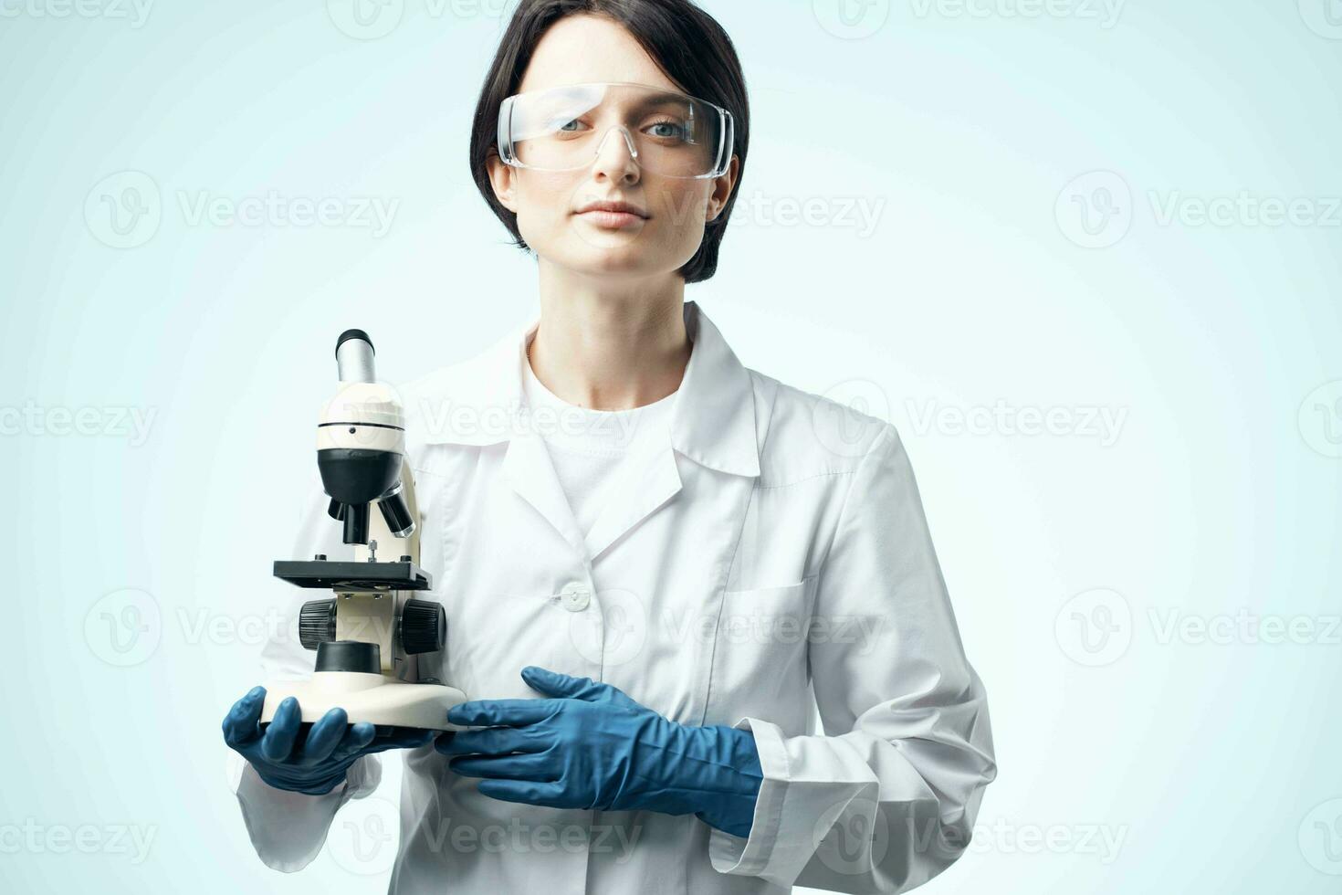 fêmea laboratório assistente dentro uma branco casaco com uma microscópio dentro a mãos do uma profissional remédio tecnologia foto