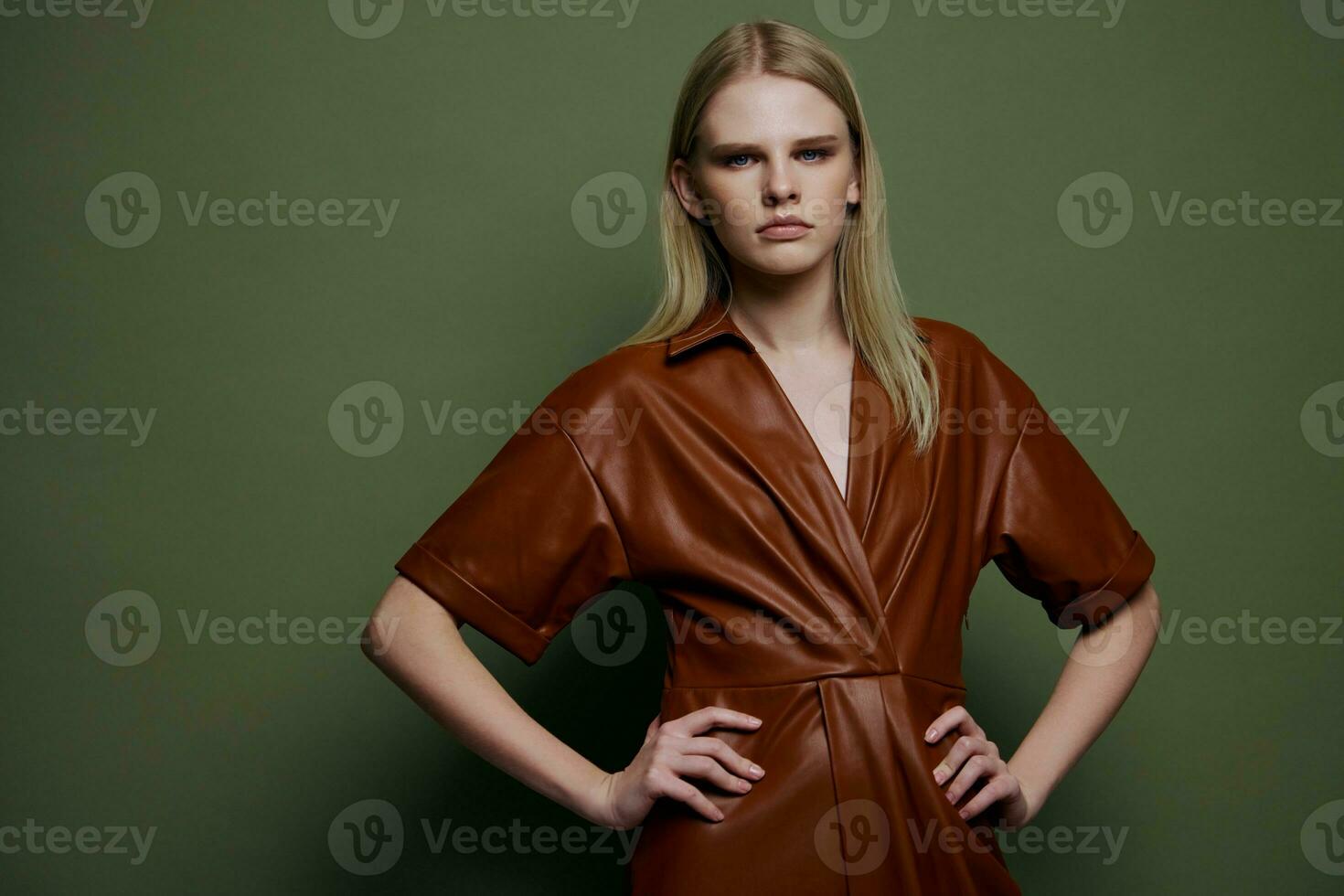 mulheres dia conceito. à moda moda autoconfiante jovem Loiras mulher segurando mãos em cintura posando isolado em sobre Oliva verde parede fundo parece às Câmera. moda oferta para marcas bandeira foto