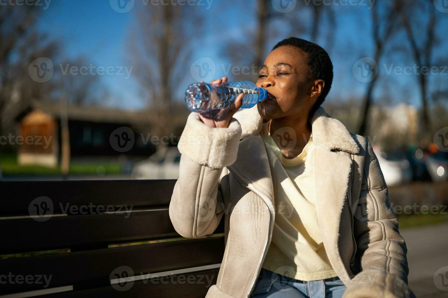 lindo afro mulher bebendo água foto
