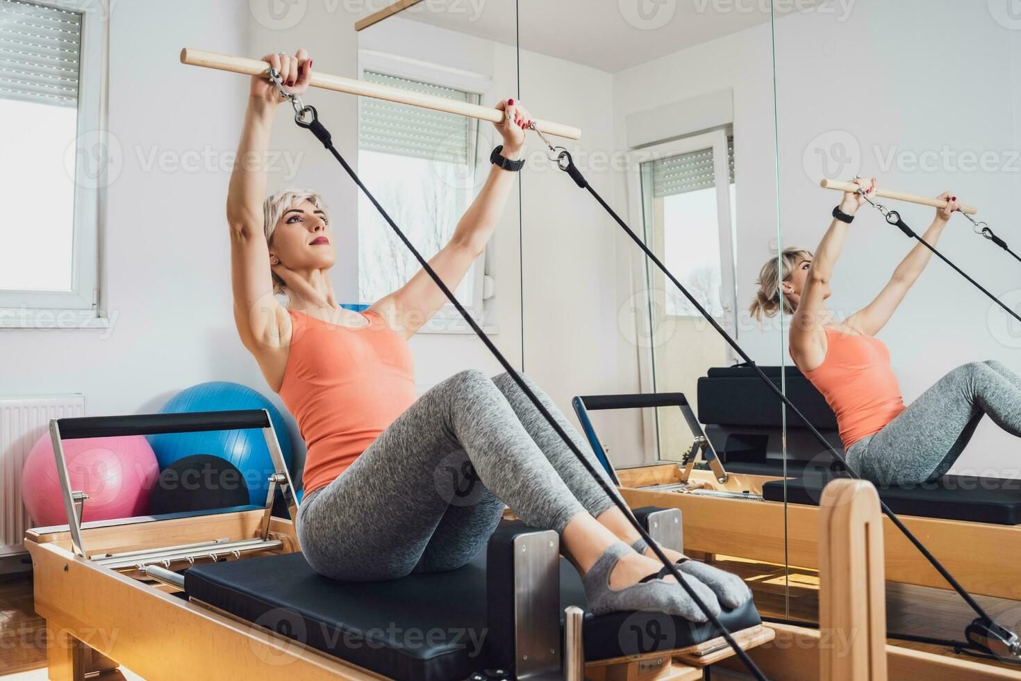 Loiras mulher é exercício em pilates reformador cama dentro dela lar. foto