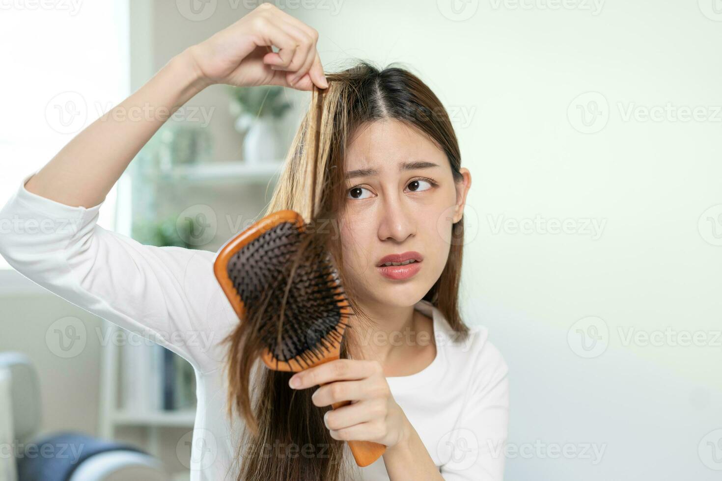 sério, preocupado ásia jovem mulher, menina segurando escovar, mostrar dela pentear, escova de cabelo com grandes perda cabelo problema depois de escovar, cabelo outono Fora em dela mão dentro vivo sala. saúde Cuidado, beleza tratamento. foto