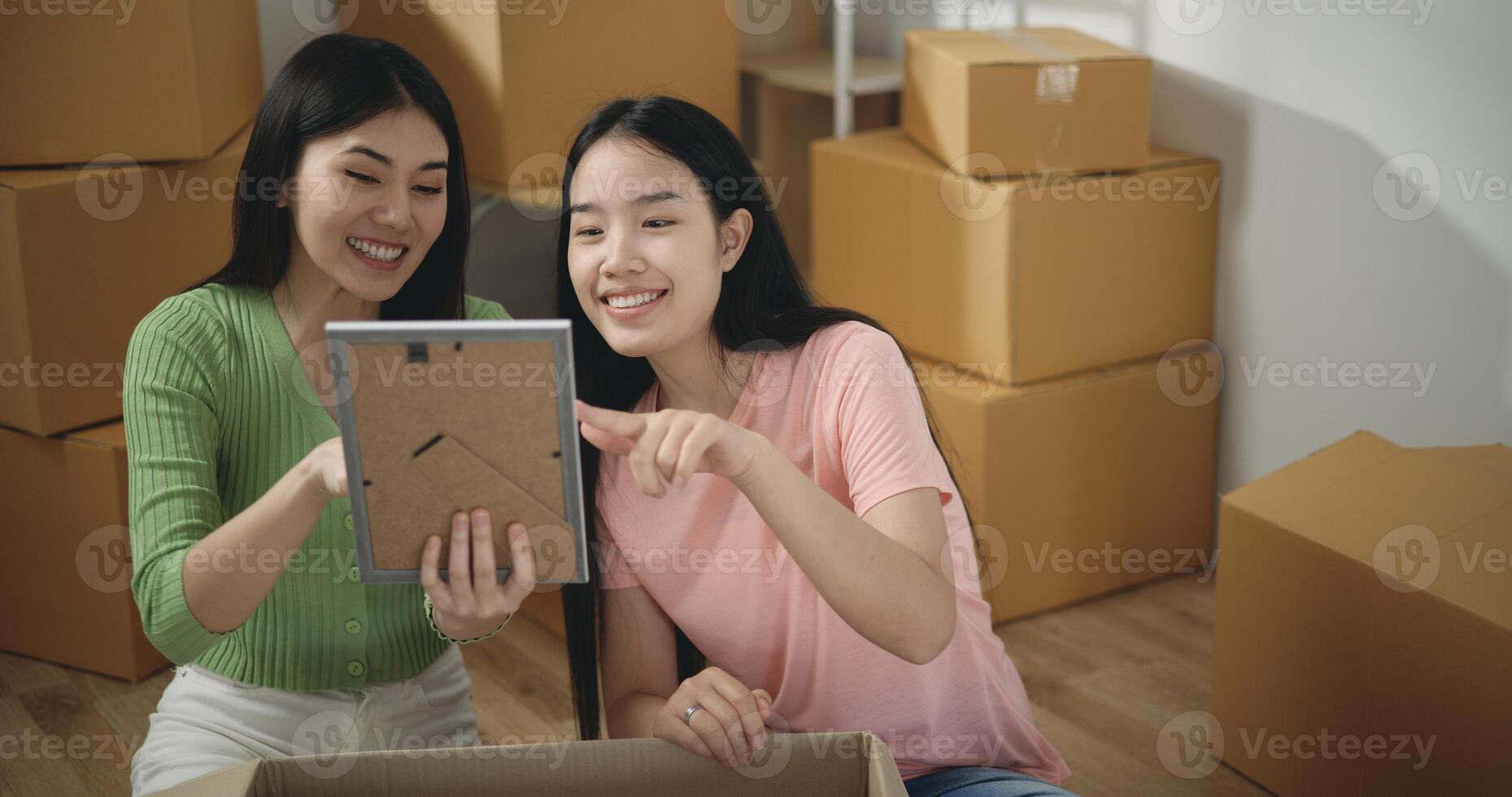 ásia jovem mulher com menina amigo apreciar para decoração dentro Novo casa foto