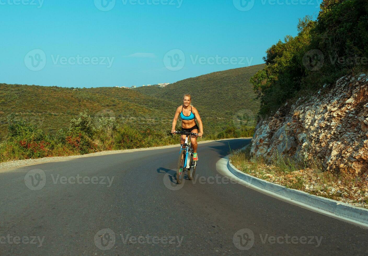 mulher ciclista equitação uma bicicleta em uma montanha estrada foto