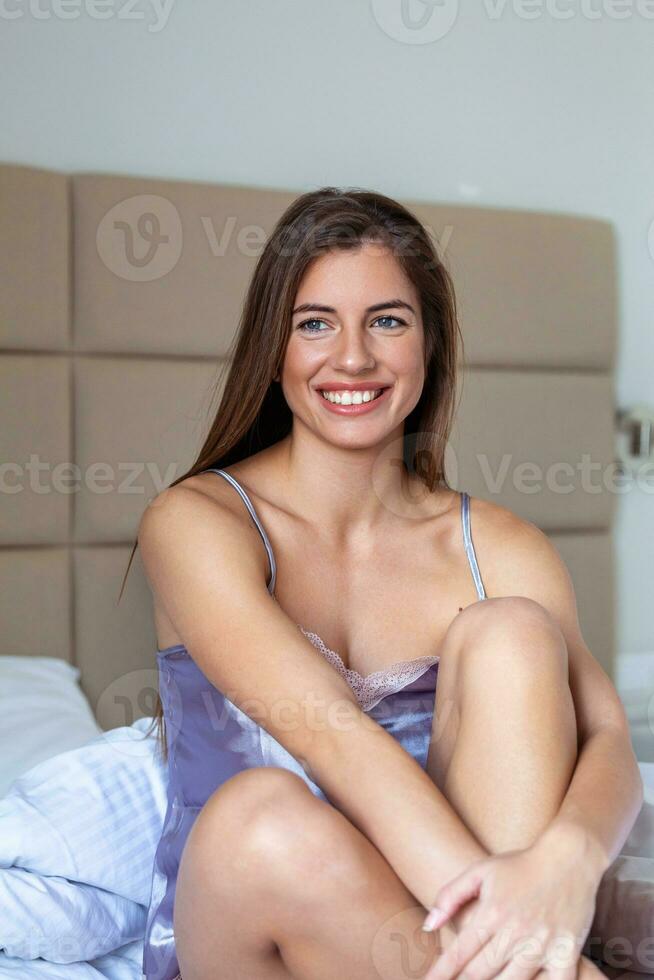 retrato bonita jovem mulher em cama dentro moderno apartamento dentro a manhã. adorável mulher posando dentro uma quarto e parece satisfeito. foto