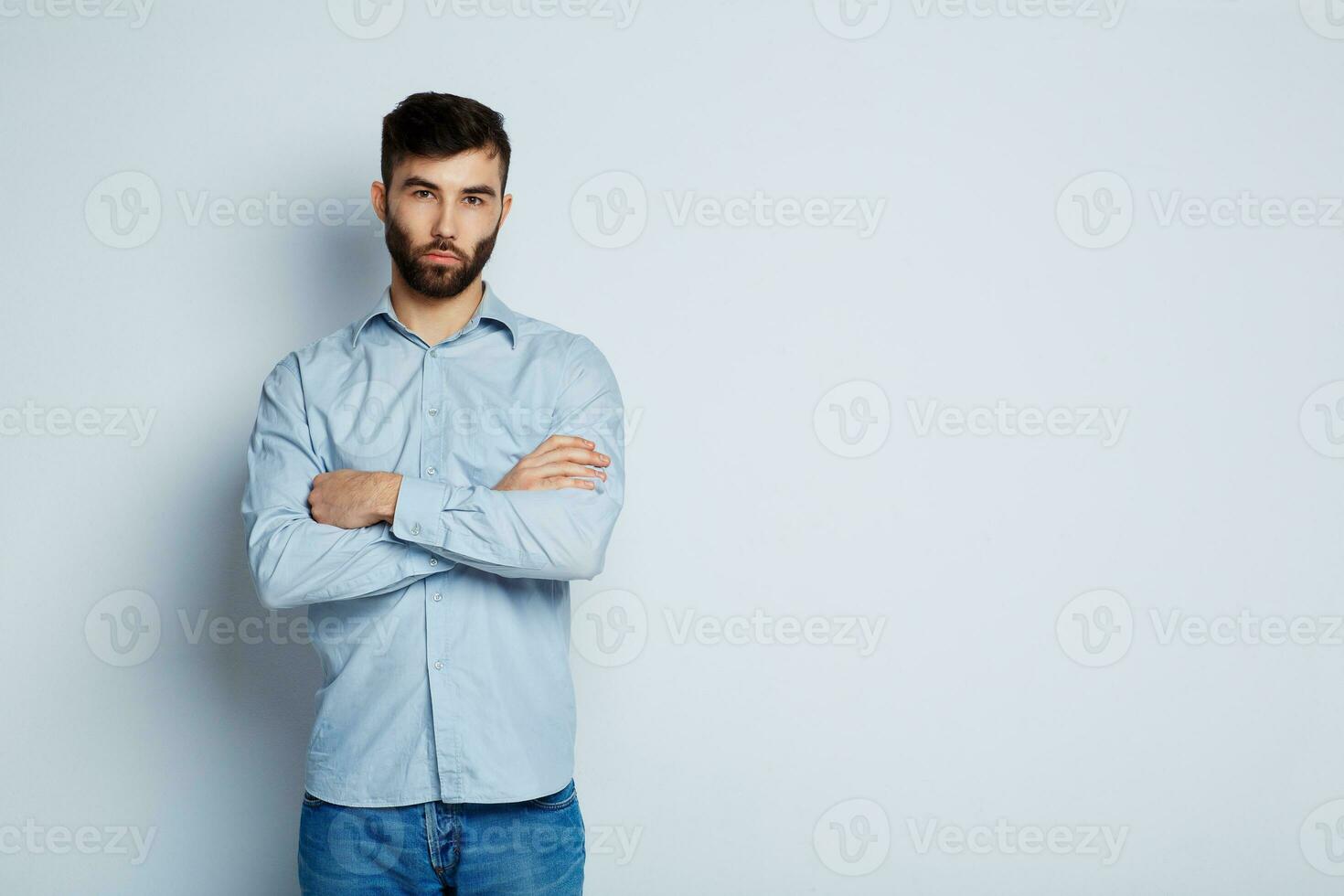 uma jovem barbudo homem com uma sério expressão em dele face foto