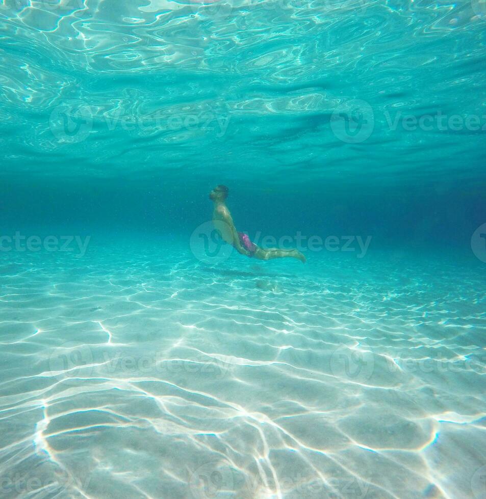 homem com óculos mergulho dentro uma azul limpar \ limpo água do a mar foto