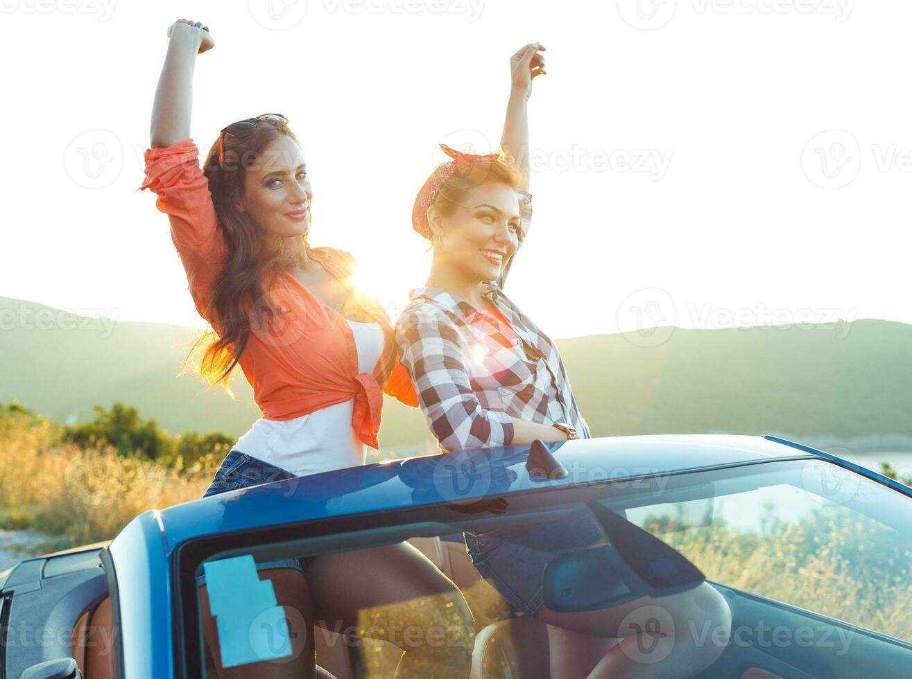 dois jovem meninas tendo Diversão dentro a cabriolet ao ar livre foto