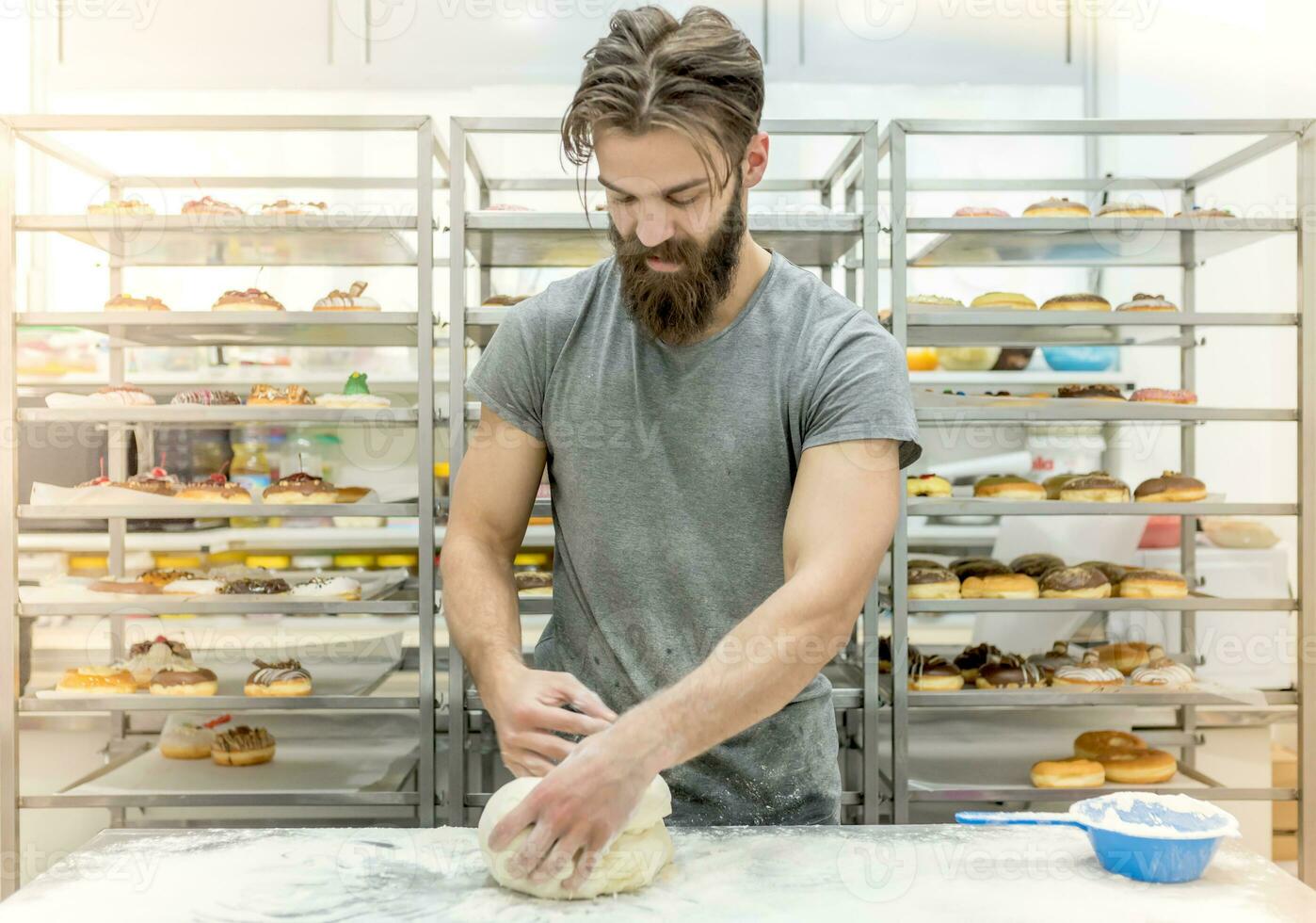 homem dentro cozinha preparando rosquinhas foto