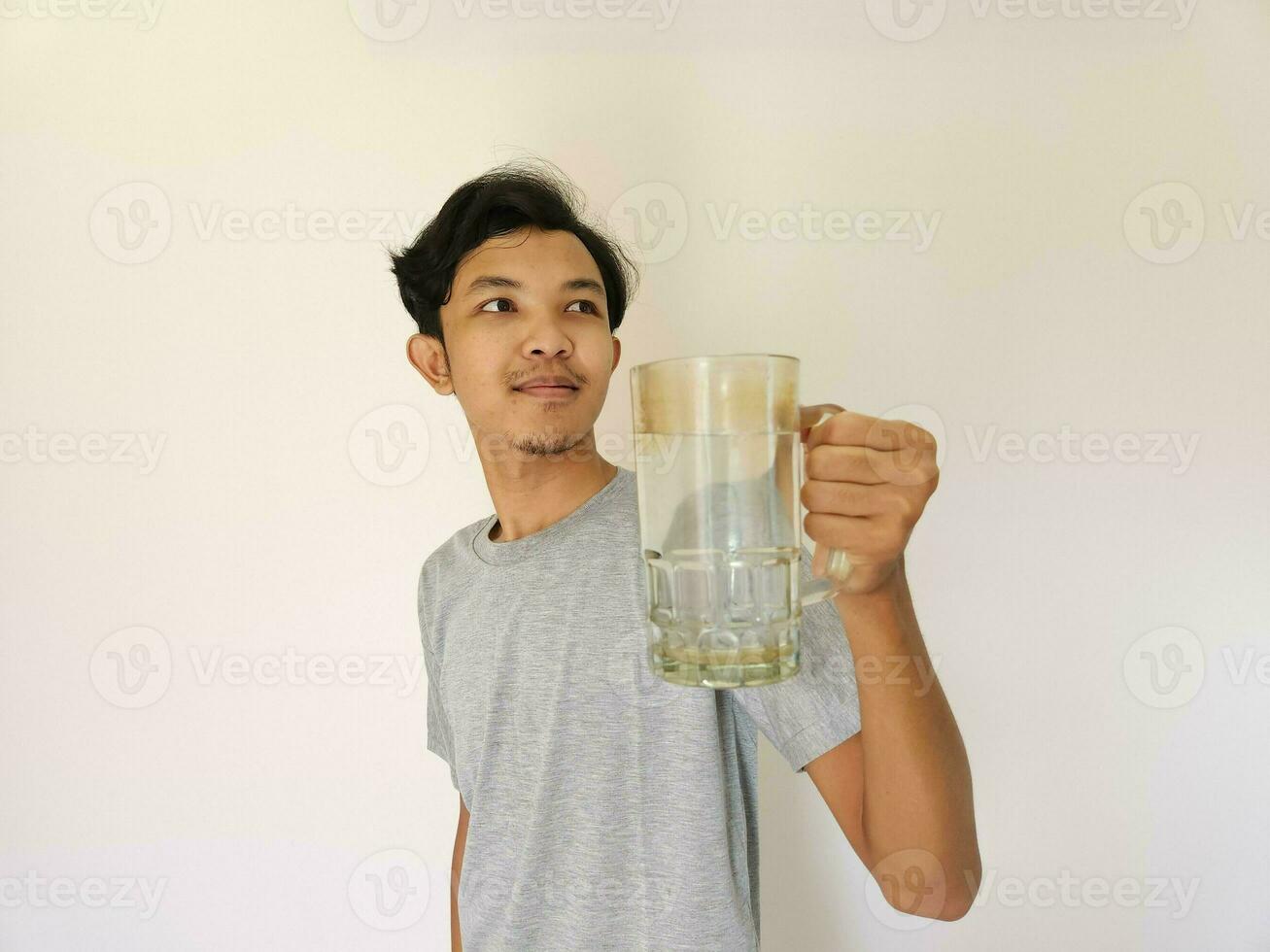 ásia homem é bebendo uma vidro do água e feliz foto