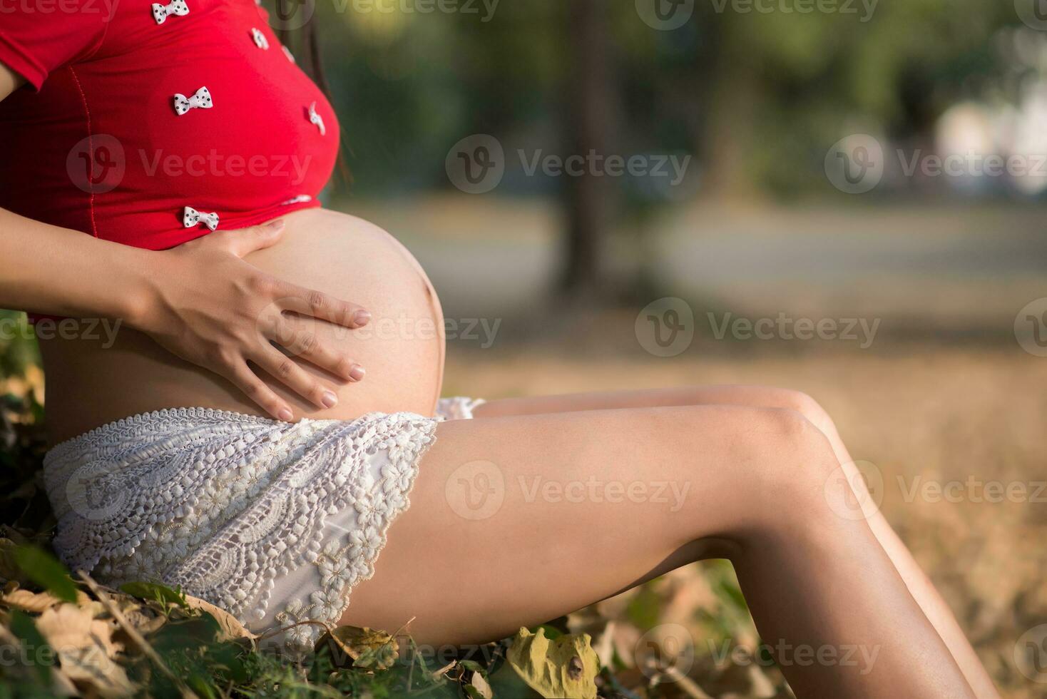 imagem de mulher grávida tocando a barriga com as mãos foto