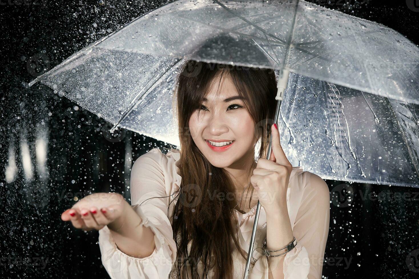 feliz chinês menina com chuva e transparente guarda-chuva foto