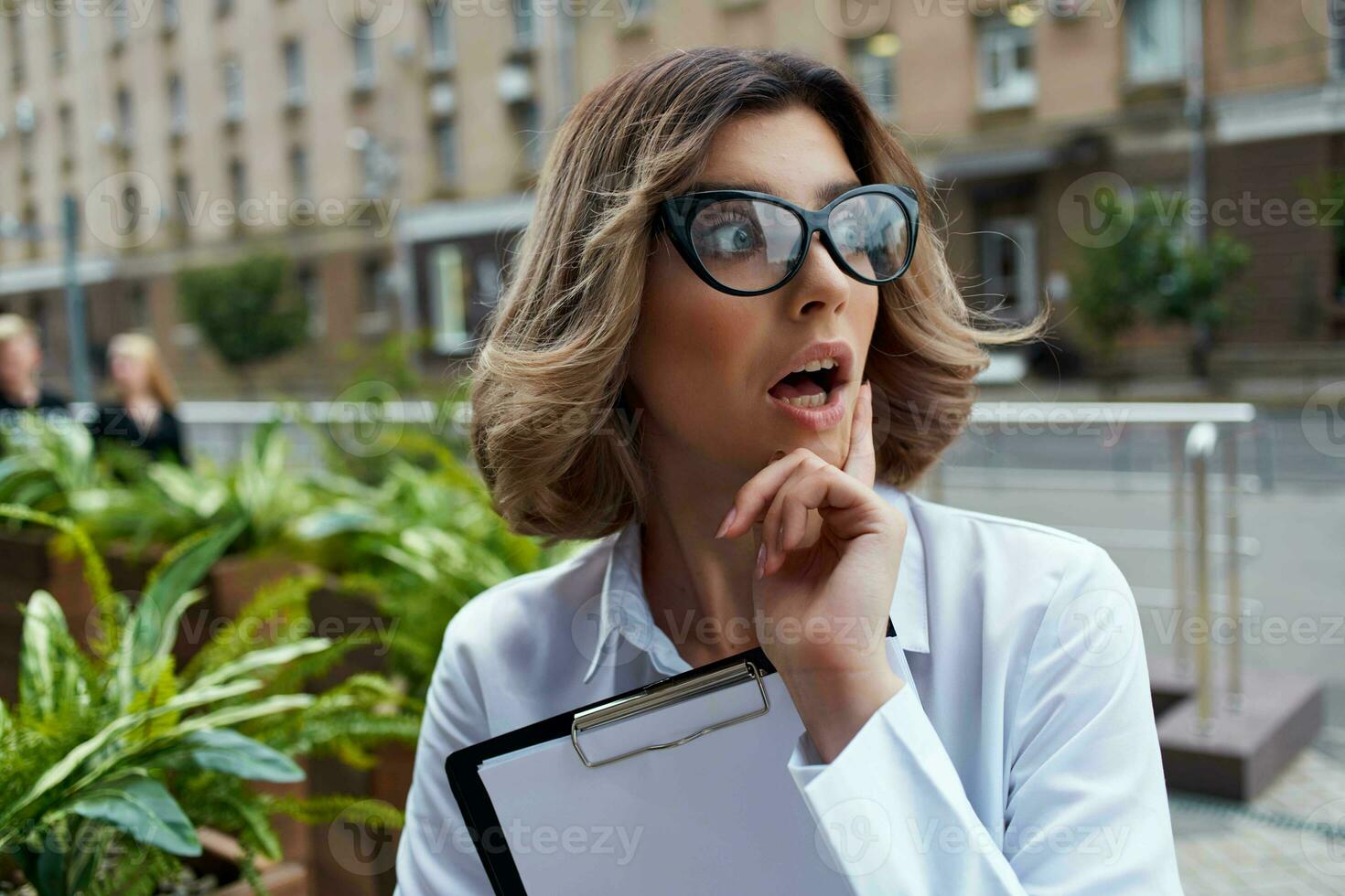 o negócio mulher dentro branco camisa em a rua com trabalhos documentos foto