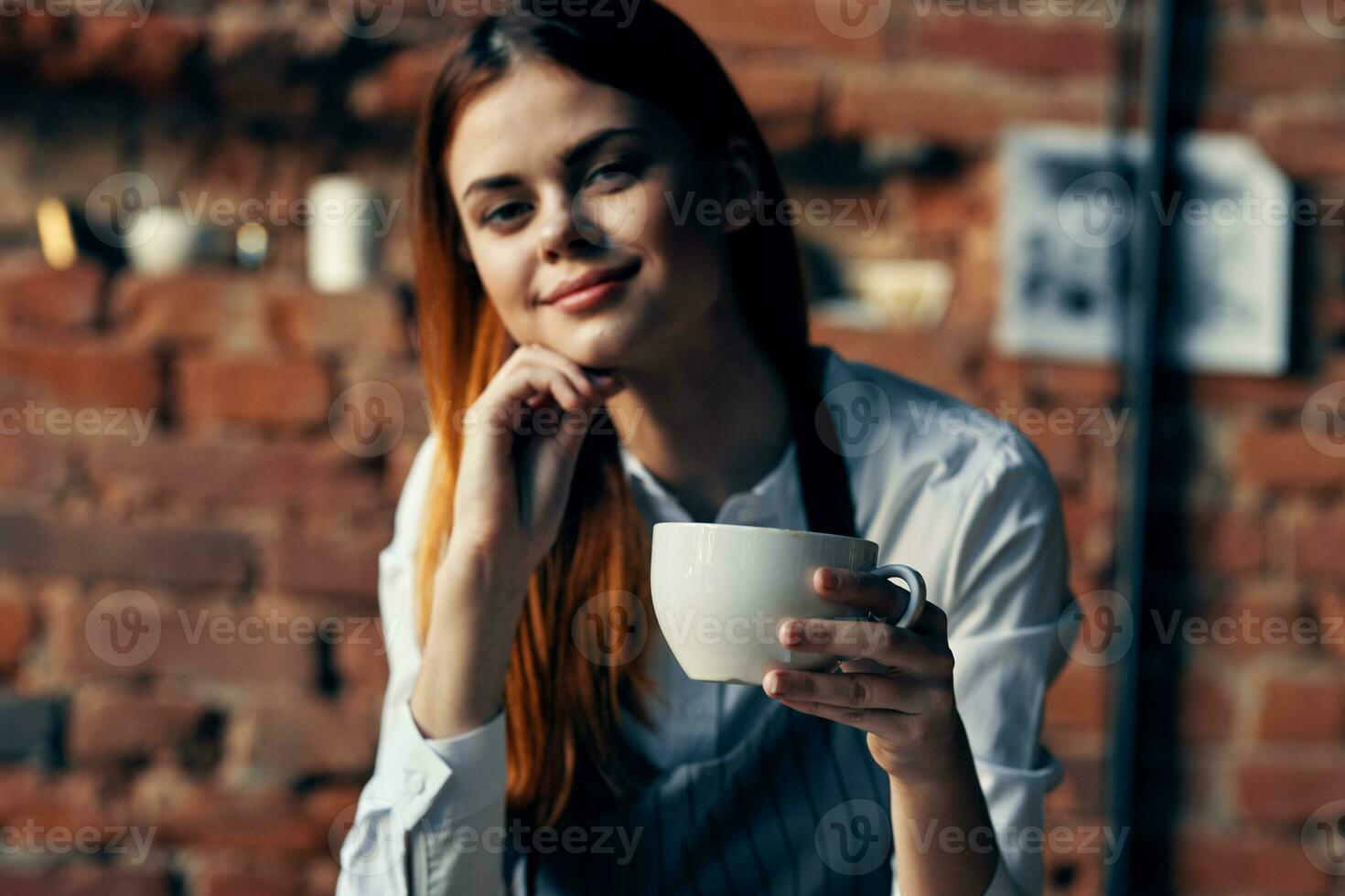 bonita mulher garçom copo com beber cafeteria tijolo parede foto