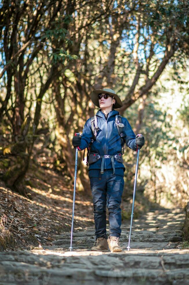 uma jovem viajante caminhada em floresta trilha , Nepal foto