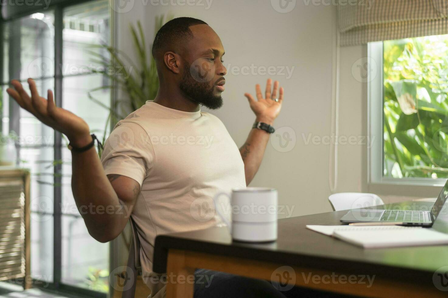 estressante africano americano homem trabalhando dentro dele casa foto