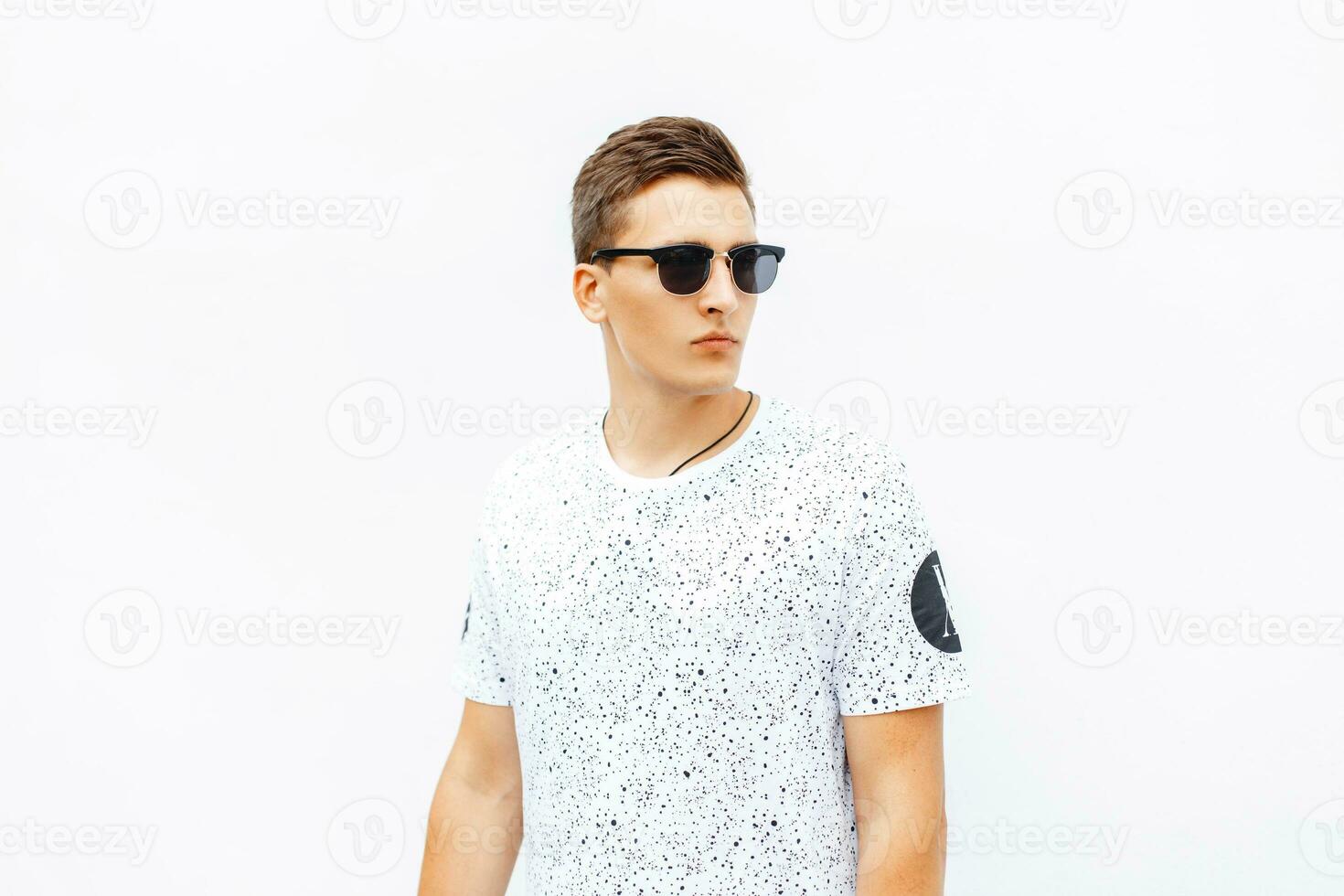 à moda jovem homem vestindo oculos de sol e cabelo em pé em branco fundo. foto
