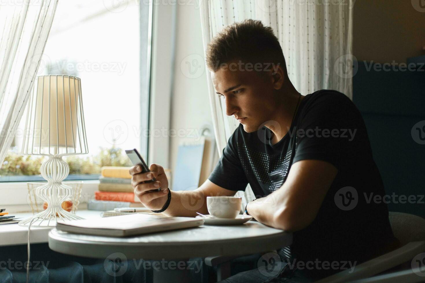 bonito homem usa a telefone e bebendo café 23334910 Foto de stock