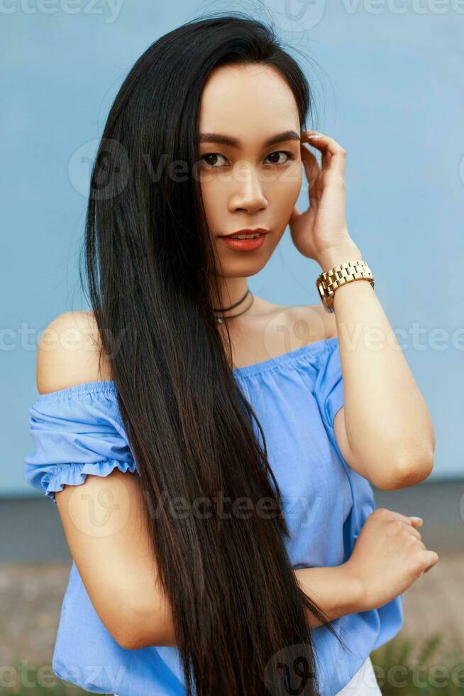 lindo vietnamita menina dentro verão moda blusa em uma azul fundo foto