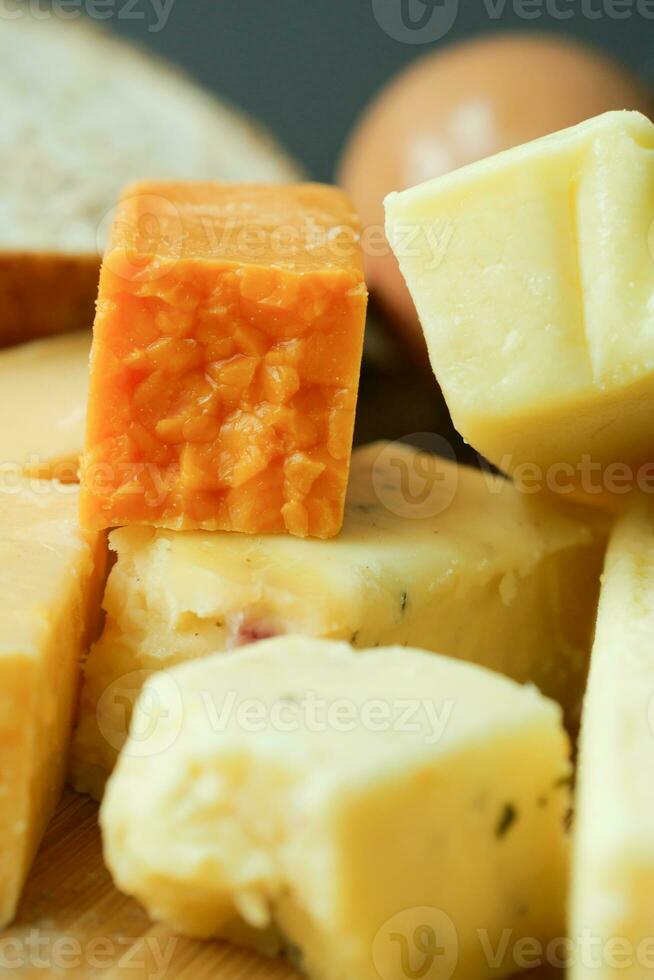 cubos de queijo cor verde, amarelo e vermelho na tábua foto