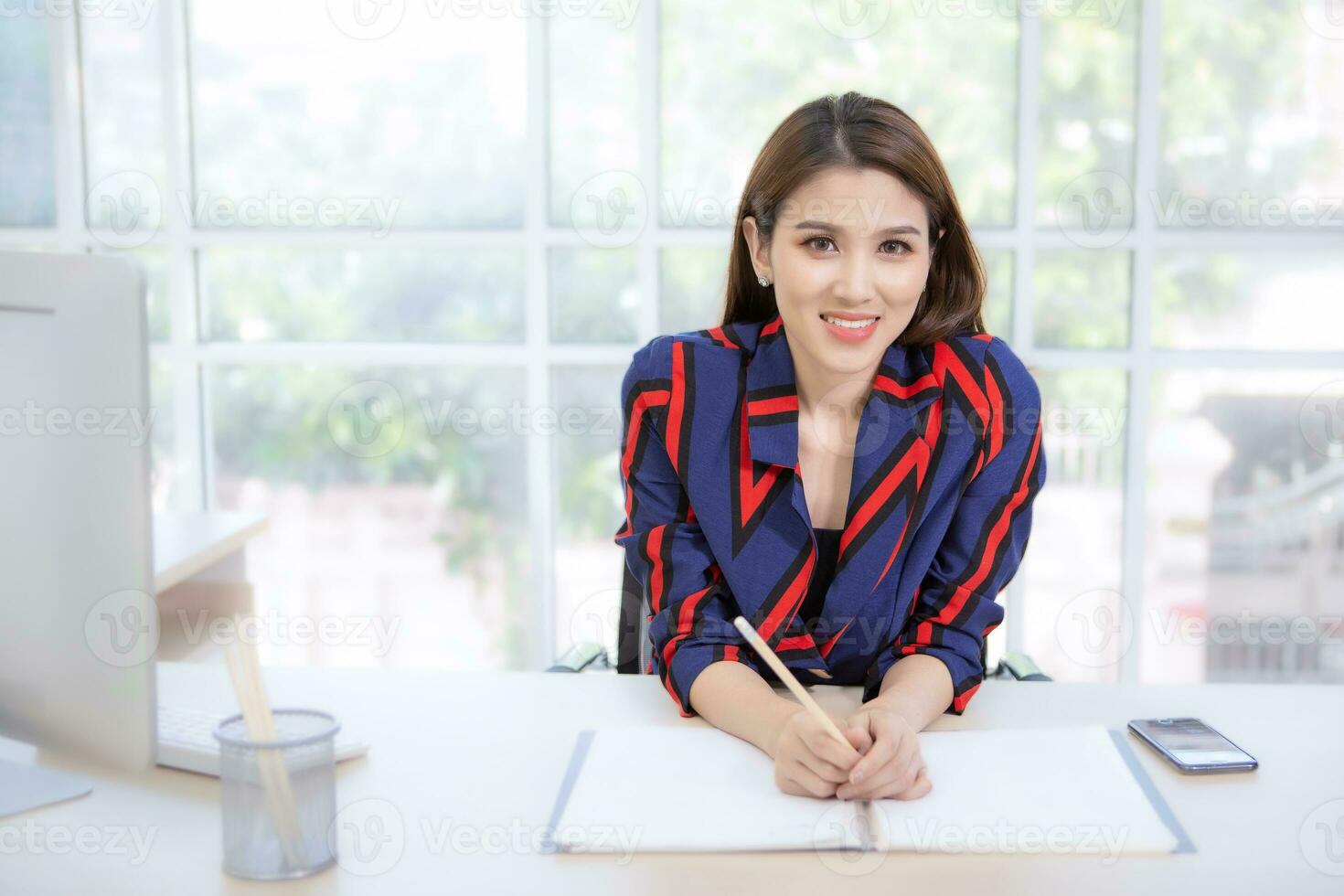 jovem profissional ásia empresária sentado pensativamente com documentos em a escrivaninha dentro dela escritório. foto