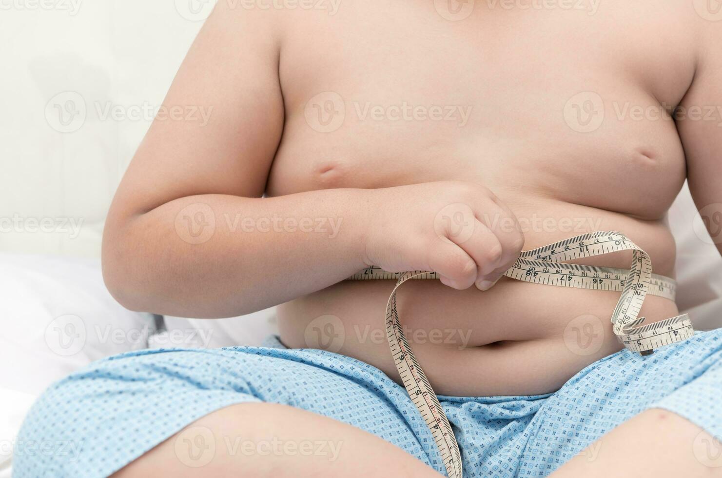 gordo Garoto medindo dele barriga com medição fita foto