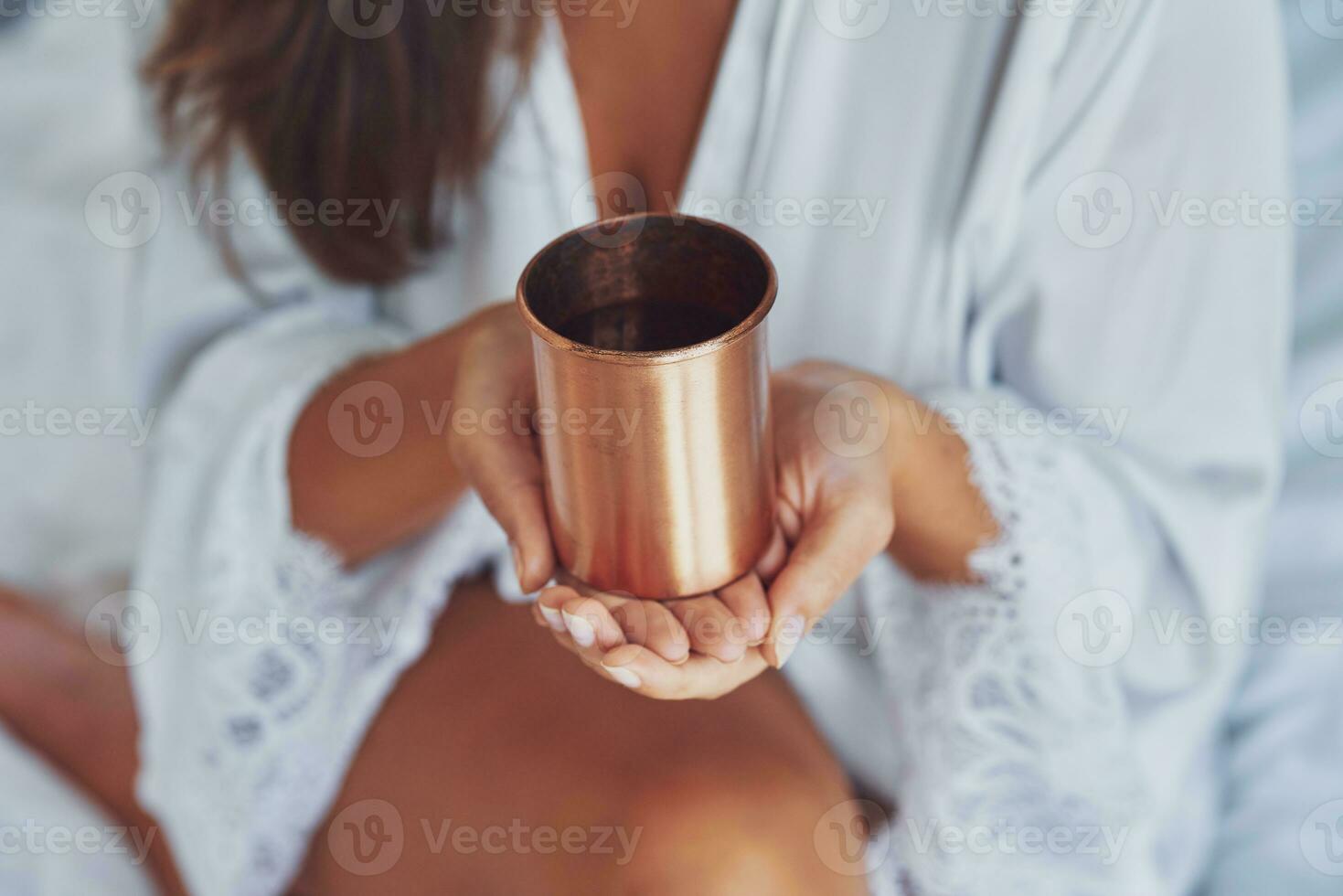 agradável olhando morena mulher com cobre copo do água foto