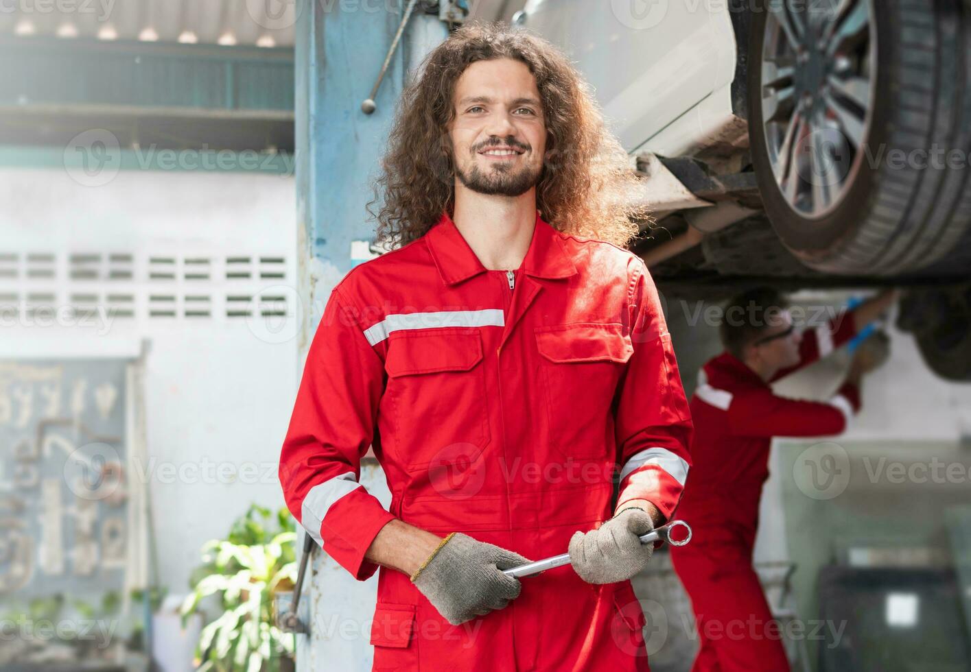 retrato do uma jovem carro mecânico dentro reparar garagem, técnico homem trabalhando dentro auto reparar comprar, carro reparar e manutenção conceitos foto