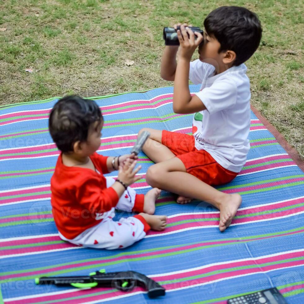 dois feliz Rapazes dentro sociedade parque, feliz ásia irmãos quem estão sorridente alegremente junto. irmãos jogar ao ar livre dentro verão, melhor amigos. criança pequena bebê Garoto jogando com dele feliz irmão dentro a jardim foto