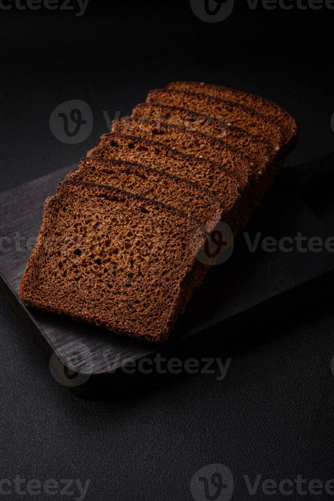 delicioso fresco Castanho pão com grãos e sementes fatiado em uma de madeira corte borda foto