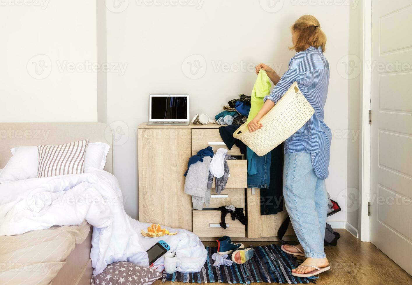 mulher entrou dela criança quarto com uma bagunça para coletar sujo coisas e limpar \ limpo acima foto