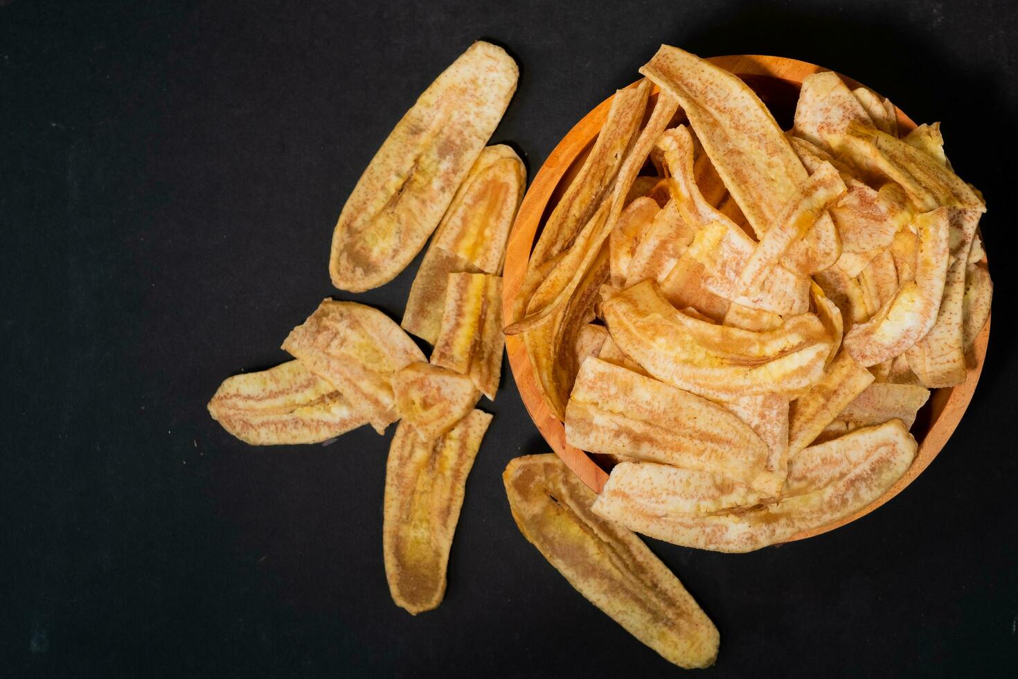 banana salgadinhos com uma doce e salgado gosto fez a partir de frito cru bananas dentro uma de madeira tigela. tradicional lanches foto