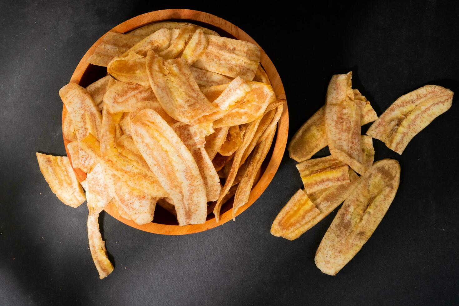 banana salgadinhos com uma doce e salgado gosto fez a partir de frito cru bananas dentro uma de madeira tigela. tradicional lanches foto