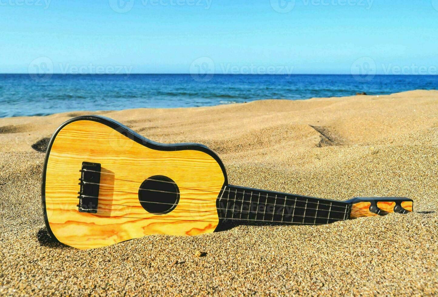 uma guitarra em a areia foto