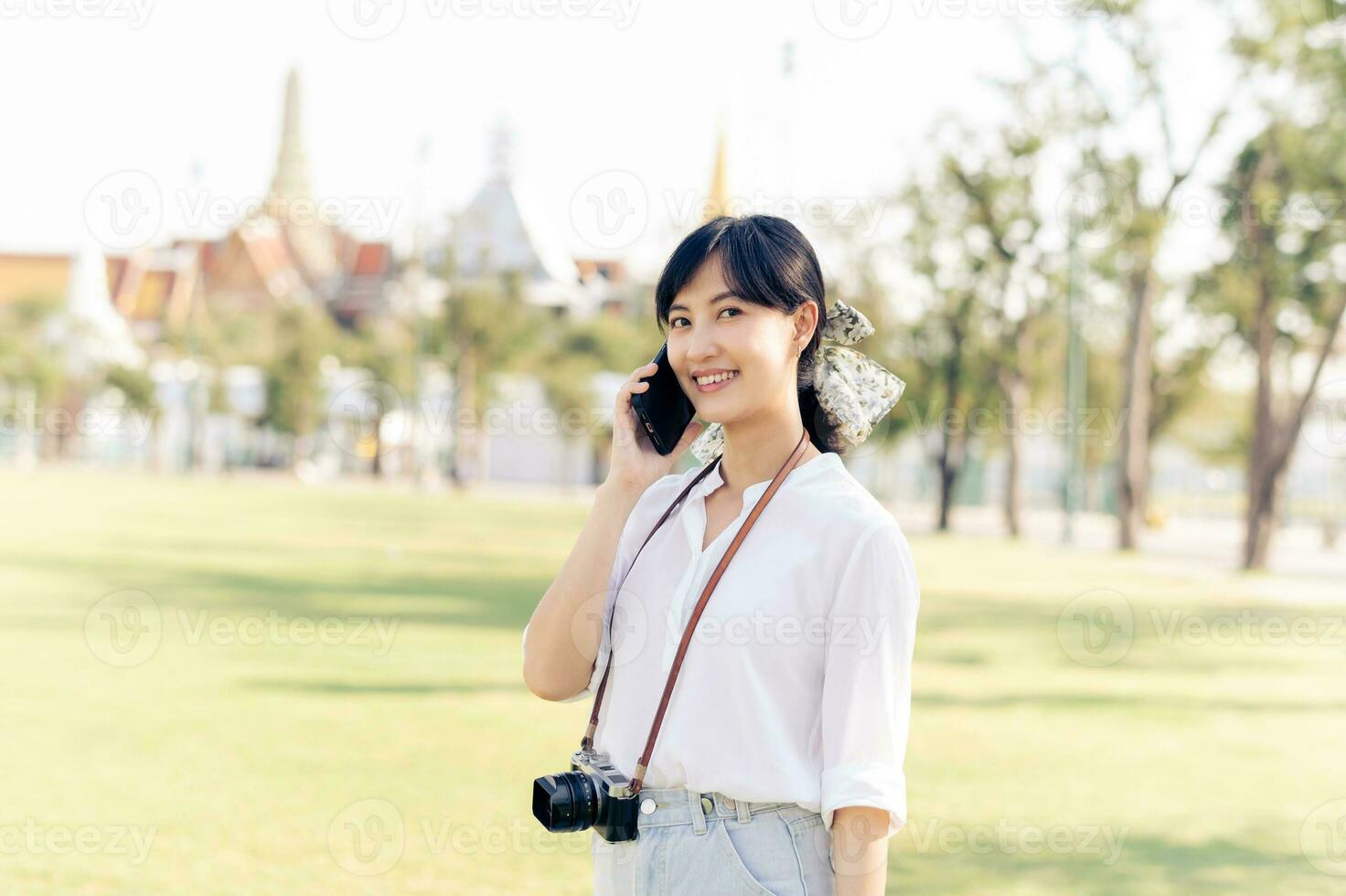 retrato lindo jovem ásia mulher com Smartphone em verão feriado período de férias viagem com a grande Palácio dentro uma fundo às Bangkok, Tailândia foto